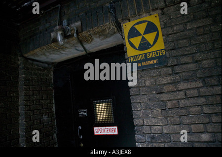 Vista di una porta d'ingresso alla stanza del seminterrato di un sovrintendente con un cartello di protezione nucleare nel cortile di un edificio in mattoni a New York City USA Foto Stock