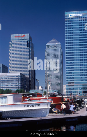 Case galleggianti ormeggiate nel bacino di Blackwall prima di torri di uffici di Canary Wharf, Docklands di Londra, Inghilterra Foto Stock