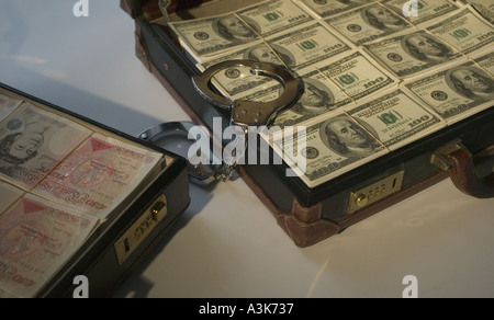 Primo piano delle fatture del dollaro nella valigetta ventiquattrore con manette sterling valigetta in background Foto Stock