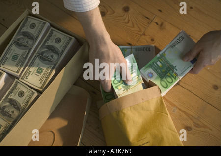 Scatola di scarpe di fatture del dollaro e l'uomo con il pacchetto di banconote in euro Foto Stock