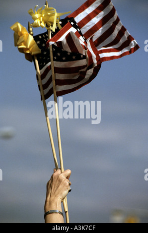 Una donna si solleva due bandierine americane durante una cerimonia di premiazione che si terrà a Fort Bragg nella Carolina del Nord STATI UNITI D'AMERICA Foto Stock