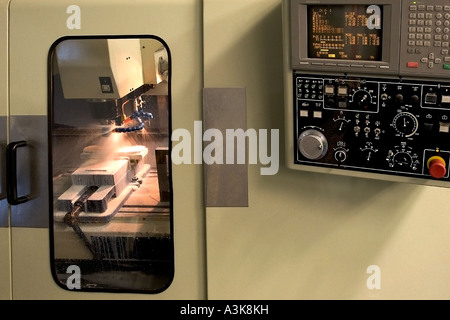 Macchina CNC (macchina di fresatura controllata da computer) la lavorazione a macchina di un componente metallico. Foto Stock