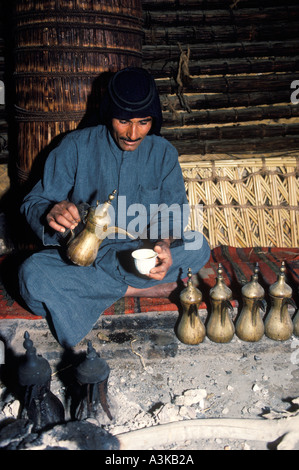 Marsh Arab man Iraq, in una casa di canne con una linea di caffettiere. 1984. Iraq meridionale vicino a Bassora 1980s HOMER SYKES Foto Stock