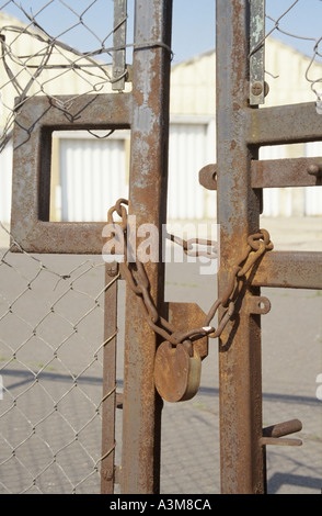 Beckton lucchetto arrugginito e catena di fissaggio delle porte chiuse unità per uso industriale Foto Stock