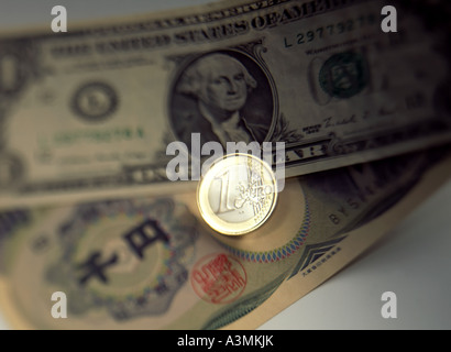 Una moneta in euro con un dollaro USA e mila yen giapponese banconote Foto Stock