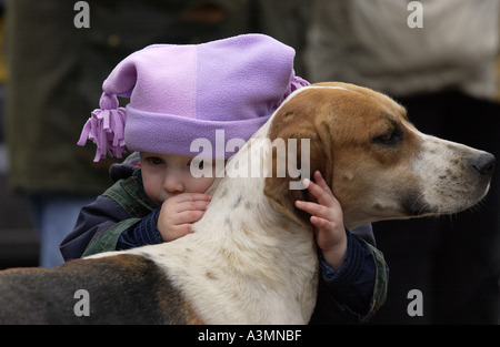 Bambino piange mentre abbraccia un foxhound presso l Heythrop Capodanno Hunt nel luogo di mercato Stow on the Wold Oxfordshire Foto Stock