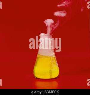 Il cloruro di ammonio di fumo liquido giallo contro bold sfondo rosso Foto Stock