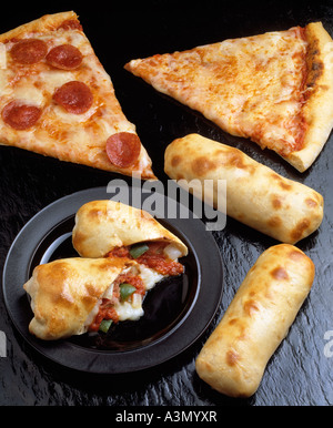 Un assortimento di pizza italiana formaggio salsiccia per pizza singola fetta stromboli salsiccia piastra nera Foto Stock