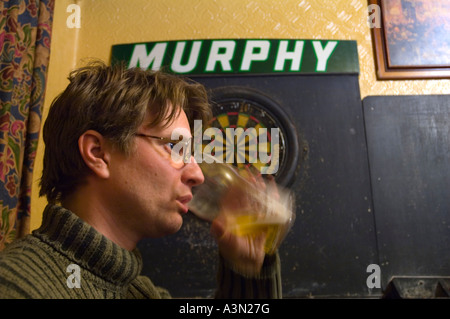 Un uomo di bere una pinta di birra in Steward Arms pub Notting Dale distretto a nord di Kensington Londra Inghilterra Regno Unito Europa Foto Stock
