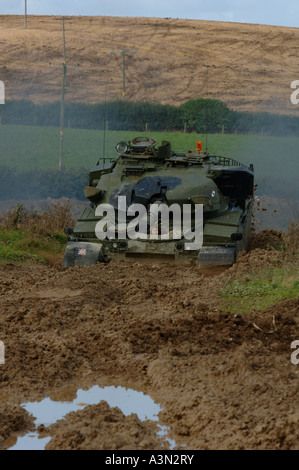 Chieftan serbatoio in azione nel campo fangoso a Bude . Cornovaglia Foto Stock