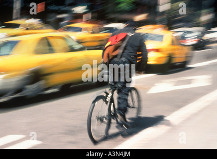 Pedalando in bicicletta su New York City Street. Uomo in bicicletta nel traffico intenso di Midtown Manhattan. Movimento sfocato. Foto Stock