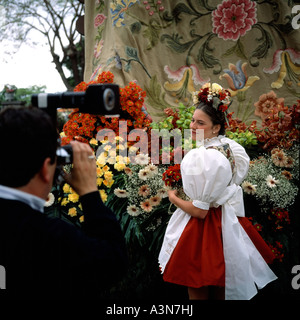 Giovane donna con il tradizionale costume in posa per la fotocamera a primavera il festival dei fiori di Funchal Madeira Portogallo Foto Stock