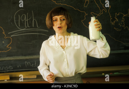 Scuola secondaria anni '90 Regno Unito. Insegnante di scienze domestiche di Greenford High School Middlesex, che tiene in mano una bottiglia di latte di pinta di vetro 1990 UK HOMER SYKES Foto Stock