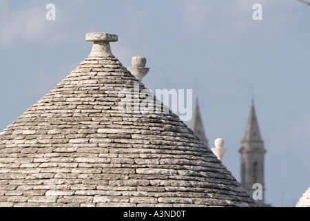 Tetto conico del trullo casa con la Basilica Cattedrale S. Medici - Alberobello, Bari, Puglia, Italia Foto Stock