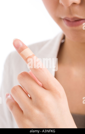Close-up di donna di dito con bendaggio adesivo Foto Stock