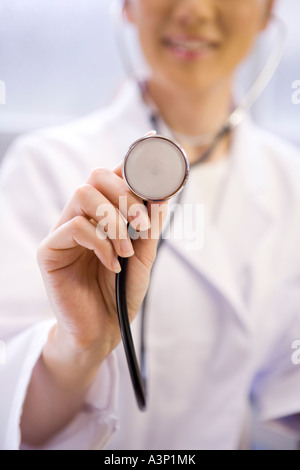 Un medico donna esame paziente con uno stetoscopio Foto Stock