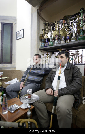 Due turche uomini fumatori loro Nargile tubazione di bolla. Corlulu Ali Pasha caffè tradizionale Istanbul Turchia Foto Stock