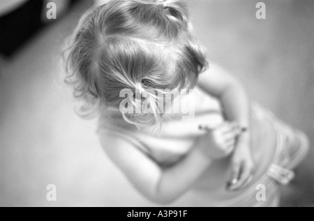 2 anno vecchia ragazza scrivendo sul suo braccio con matita colorata Foto Stock