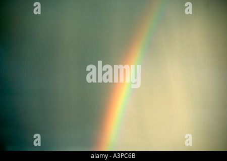 Arcobaleno nel cielo tempestoso con pioggia obliqua Foto Stock