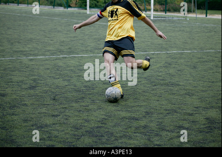 Giocatore di football calci la palla Foto Stock