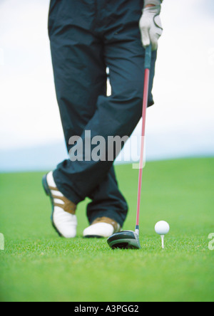 Il Golfer in piedi accanto a tced pallina da golf, sezione bassa Foto Stock