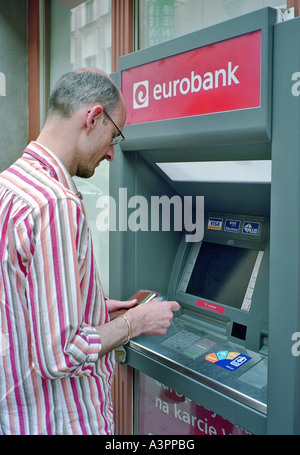 Un uomo a un bancomat a Poznan, Polonia Foto Stock