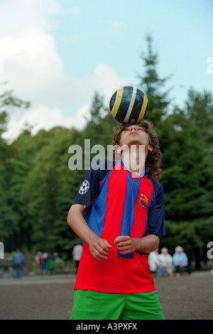 Giovane uomo in possesso di un pallone da calcio sulla sua testa, Kaliningrad, Russia Foto Stock