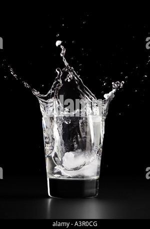 Acqua Splash, facendo cadere un cubetto di ghiaccio in un bicchiere di acqua Foto Stock