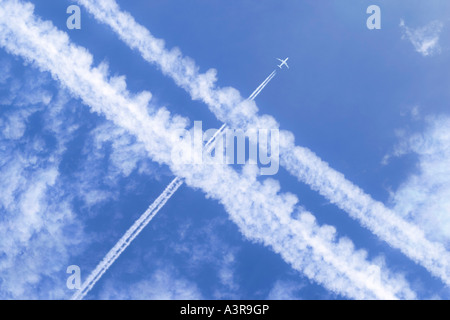 Sentieri di vapori e getti di passeggeri in alto nel cielo Foto Stock