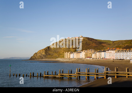 Lungomare vittoriano edifici e pennelli in legno sulla spiaggia del nord nella città balneare di Cardigan Bay. Aberystwyth Ceredigion REGNO UNITO Galles Foto Stock