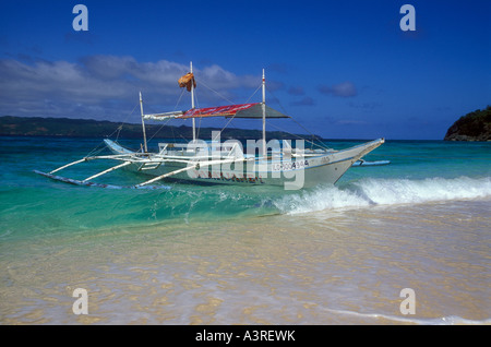 Outrigger barca ancorata sulla spiaggia sabbiosa, Boracay Island. Foto Stock