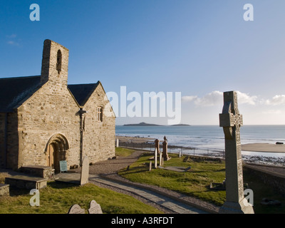 Croce di pietra e il XII secolo St Hywyn s chiesa Eglwys Hywyn Sant nella baia di Aberdaron su Lleyn Peninsula Aberdaron Gwynedd Wales UK Foto Stock