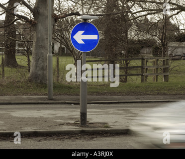 Un blu brillante girare a sinistra cartello stradale freccia contro un sfondo muto Foto Stock