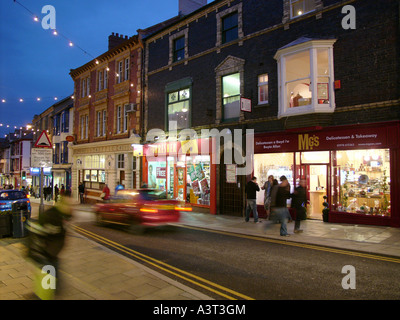 Grande Darkgate street Aberystwyth di notte. La strada principale dello shopping nel Galles occidentale town, negozi illuminati Foto Stock