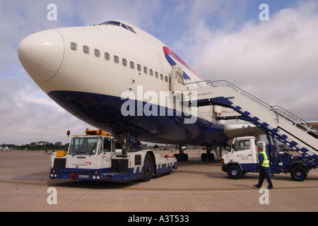 British Airways Boeing 747 jumbo parcheggiato su un aeroporto grembiule con rimorchiatore e aria scale Foto Stock