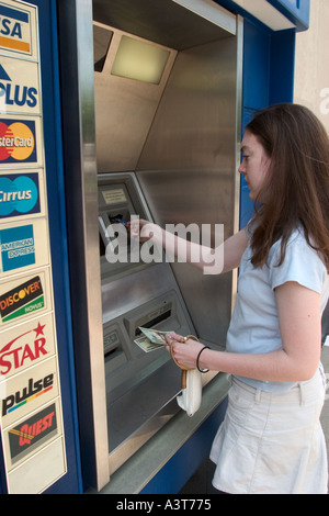 Adolescente utilizza ATM a ritirare i soldi dalla banca Foto Stock