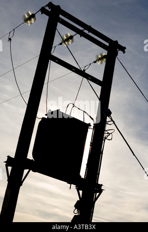 Linea elettrica di alimentazione con trasformatore in sillouette contro il cielo, REGNO UNITO Foto Stock