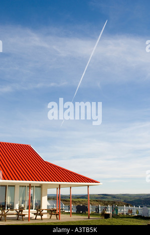 Il bianco e il rosso edifici su Constitution Hill aberystwyth con contrail di aereo jet nel cielo Foto Stock