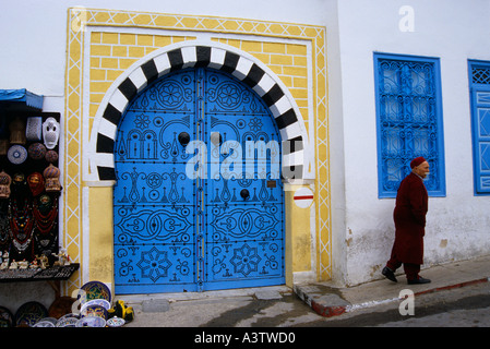 Porta ornamentali e un vecchio uomo con abiti tradizionali su una strada di Sidi Bou Said Tunisia Foto Stock
