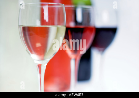 Bottiglie di bianco e rosso vino rosato dietro chiaro bicchieri pieni e un bianco sfondo isolato Foto Stock