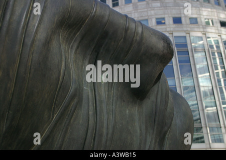 Arte moderna scultura di una testa umana e di fronte a Canary Wharf a Londra con una parete di vetro ufficio torre grattacielo di blocco Foto Stock