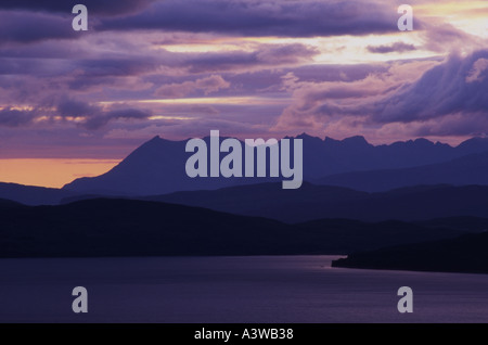 Viola tramonto sul nera frastagliate montagne Cuillin sull'Isola di Skye in Scozia con un effetto a strati per le colline Foto Stock