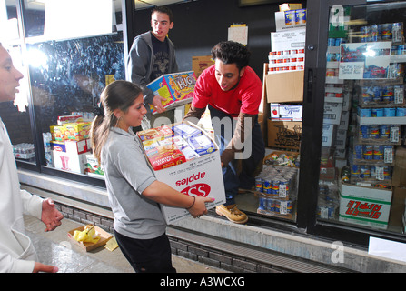 Alta scuola i bambini la raccolta di cibo per la carità. Aiutando i bisognosi, Foto Stock