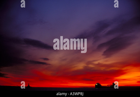 Un cargo frangiflutti e di luce si stagliano all'alba IN MARQUETTE S porto superiore sotto un cielo ampio Foto Stock