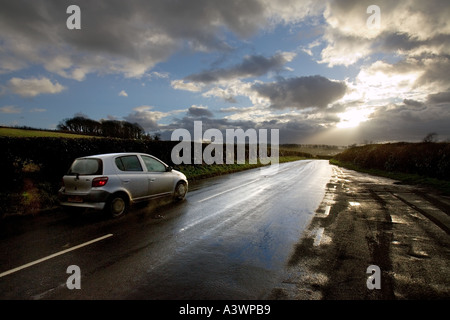 Velocità, guida veloce su strada bagnata verso le nuvole tempesta, Isola di Wight, Inghilterra Regno Unito Foto Stock