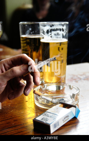 Il fumo di sigarette in un pub fumosi con bicchieri di birra, REGNO UNITO Foto Stock