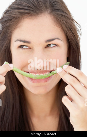Una giovane donna mangiare asparagi close up Foto Stock
