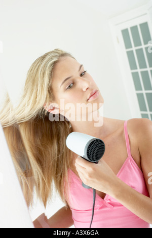 Giovane donna blow asciugando i capelli Foto Stock