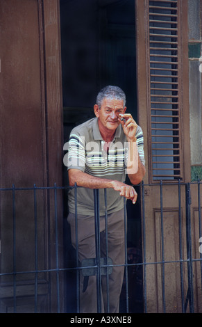 Uomo di fumare un sigaro sul suo balcone Havana Cuba Foto Stock