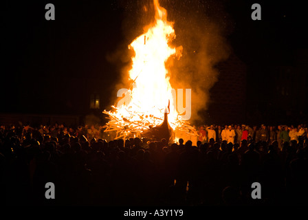 dh Up Helly AA fuoco processione LERWICK SHETLAND Guizers guardare Vichingo longship galley Moogi scendere a Burning sito festival shetlands barca Foto Stock